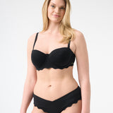 Woman wearing black colored bikini with scalloped edges