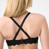 Woman wearing black colored bikini top with crossing straps in the back