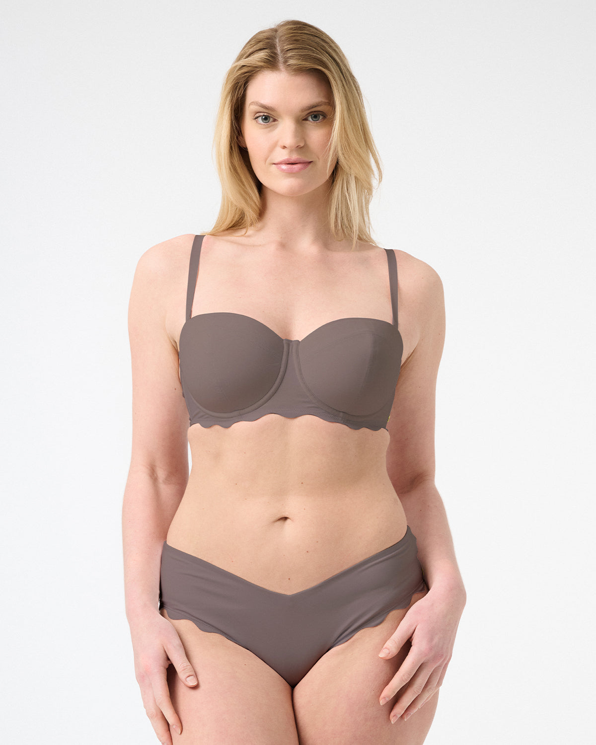 A woman wearing a brown balconette bikini top with underwire and a matching bottom, both with a smooth texture.