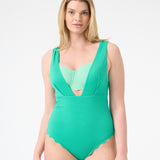 A model is wearing a green one-piece swimsuit with a deep v-neckline and sleeveless design.