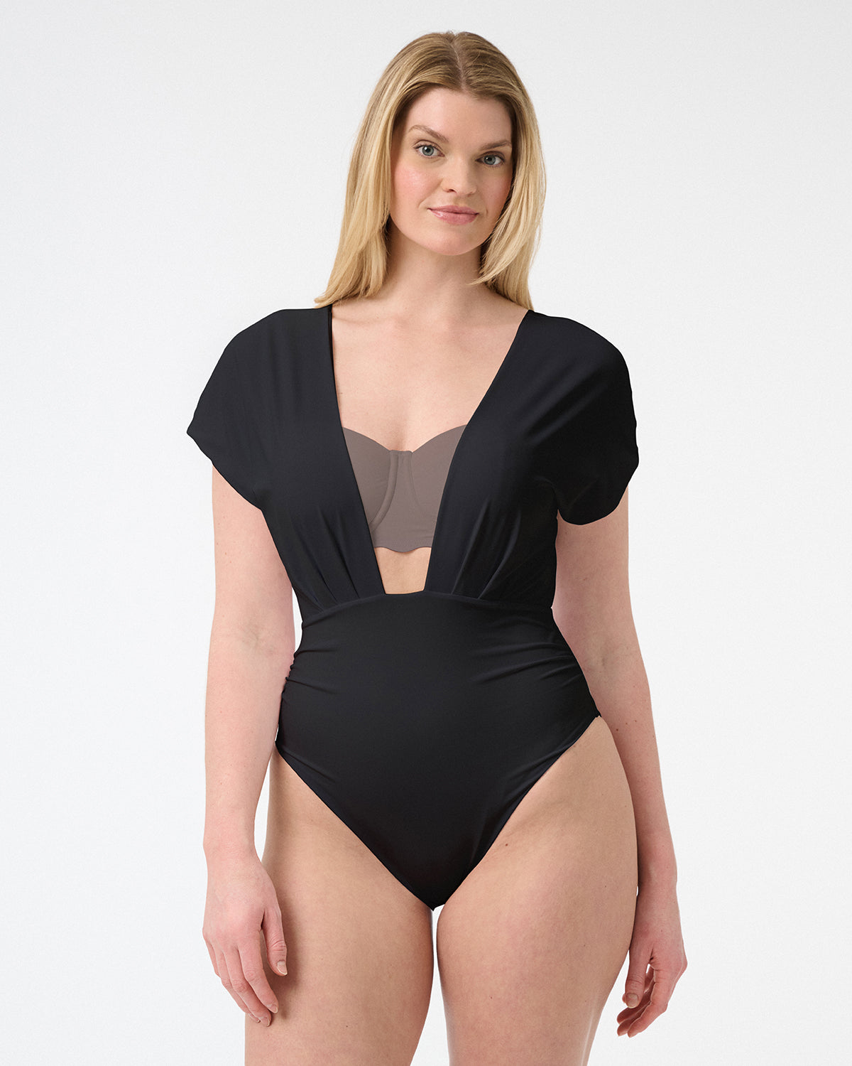 Woman wearing black capped sleeve swimsuit with deep plunging neckline