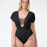 Woman wearing black capped sleeve swimsuit with deep plunging neckline
