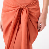 A woman wearing peach wrap skirt with