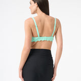 The back of a person wearing a green swim top and a black swim sarong wrapped around the waist.