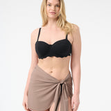 A person wearing a black swim top and a brown swim sarong wrapped around the waist.