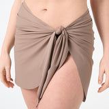 A person wearing a brown swim sarong wrapped around the waist.