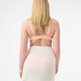 Back of a person wearing a peach swim top and a white swim sarong wrapped around the waist.