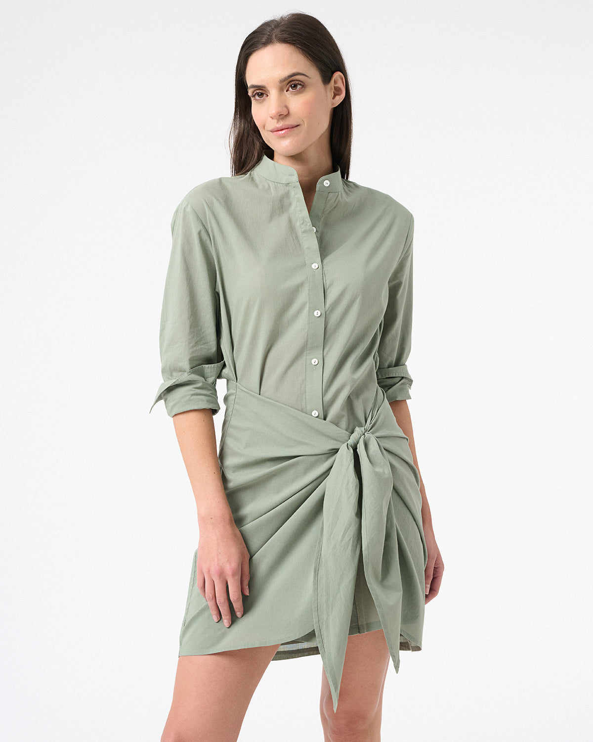 Woman wearing green long sleeve wrap dress in sea salt with buttons down the front with a tied skirt