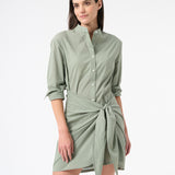 Woman wearing green long sleeve wrap dress in sea salt with buttons down the front with a tied skirt