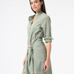 Woman wearing green sea salt wrap dress with long sleeves and buttons down the front