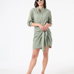 Woman wearing green sea salt wrap dress with green sunglasses and brown sandals