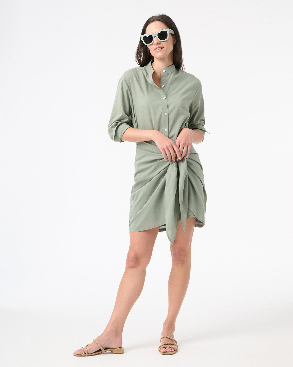 Woman wearing green sea salt wrap dress with green sunglasses and brown sandals