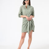 Woman wearing green sea salt wrap dress with green sunglasses and brown sandals