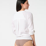 Back view of white gauze button-down shirt with rolled sleeves, paired with Cocoa bikini bottoms for a relaxed resort style
