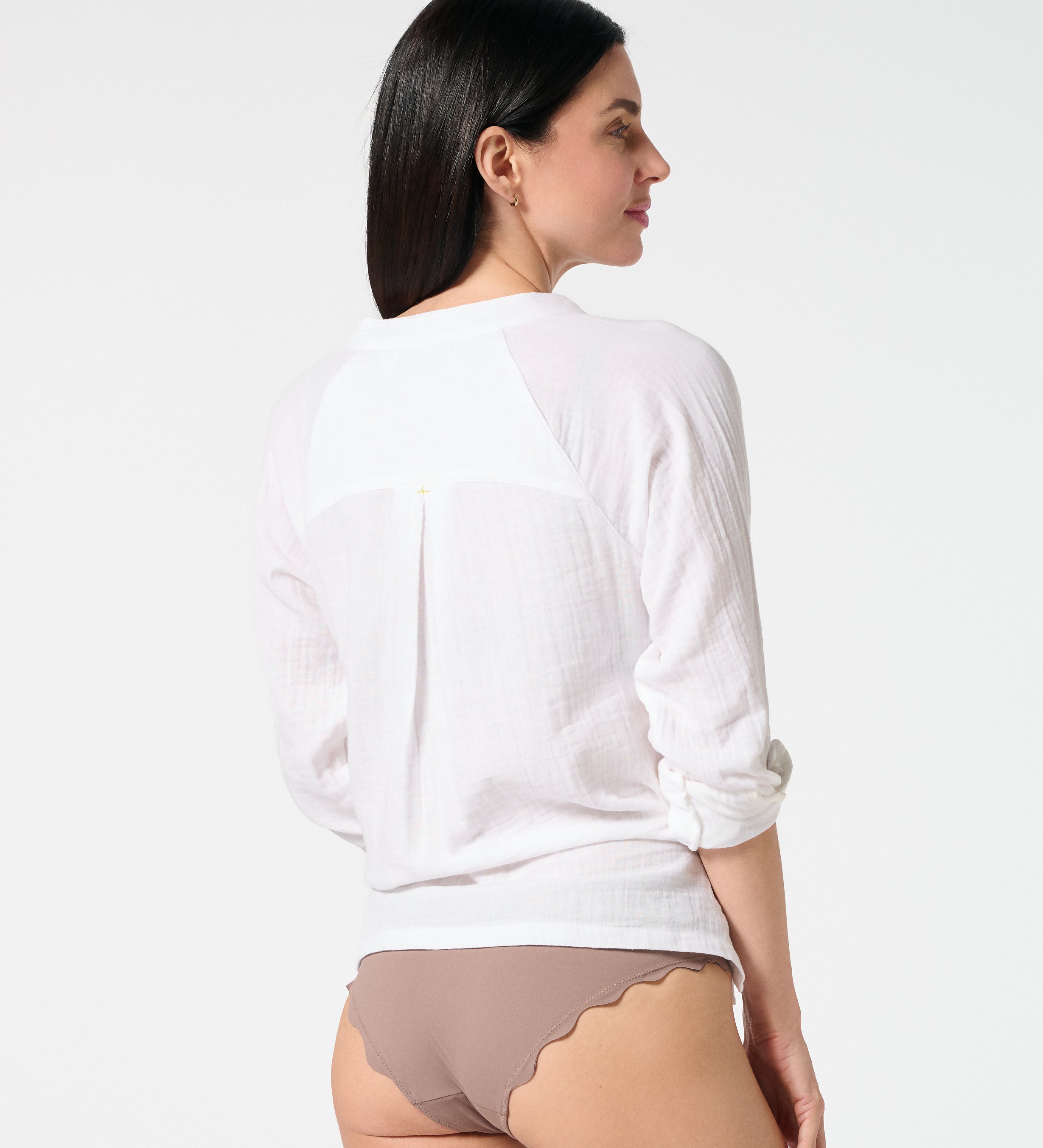 Back view of white gauze button-down shirt with rolled sleeves, paired with Cocoa bikini bottoms for a relaxed resort style