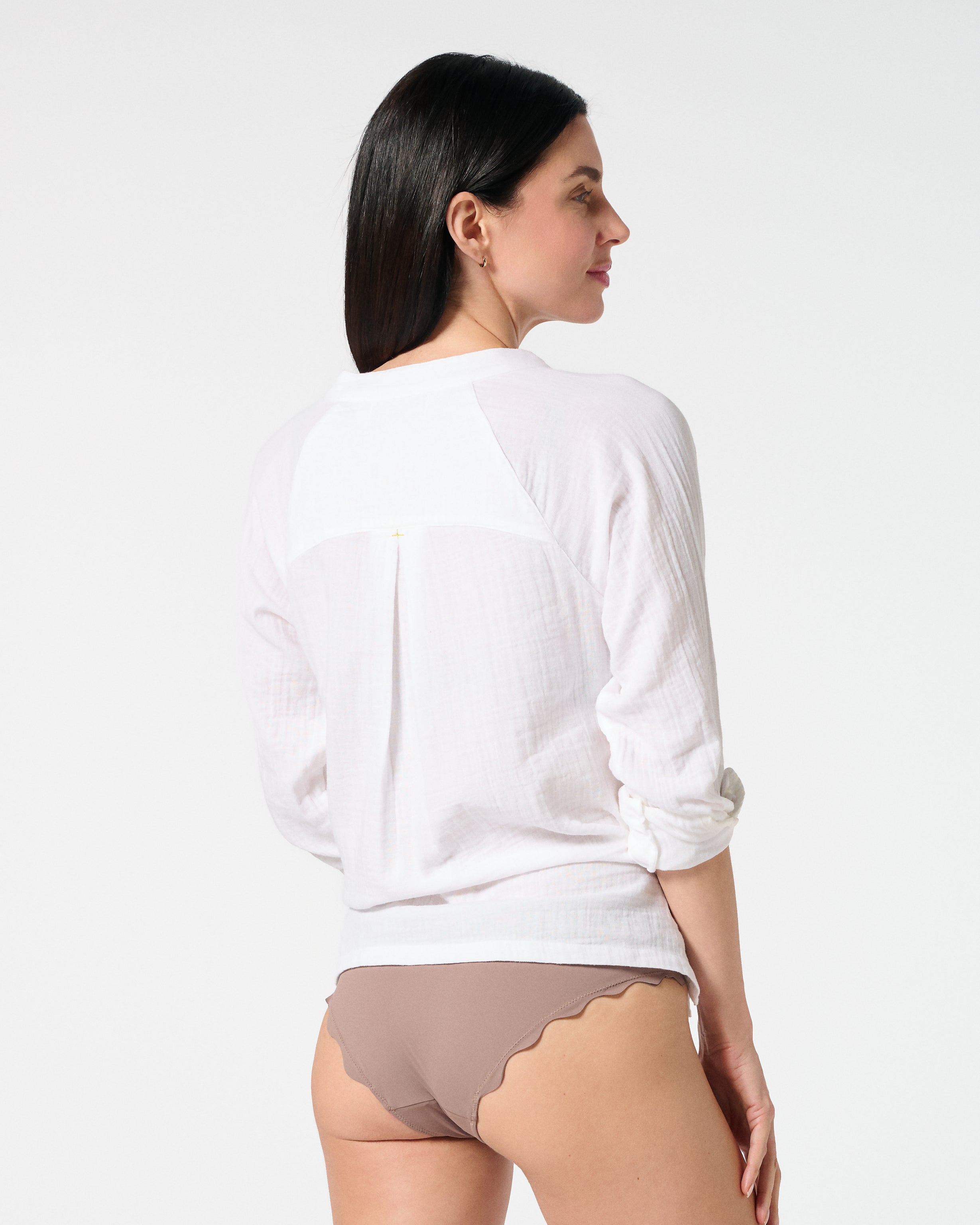 Back view of white gauze button-down shirt with rolled sleeves, paired with Cocoa bikini bottoms for a relaxed resort style
