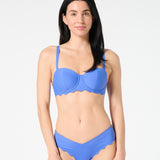 Woman wearing a blue grotto bikini set on a white background