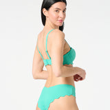 Side angle of model wearing Deep Dive textured balconette bikini top and matching scalloped Iris bikini bottoms by Siren + Sage