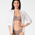 White gauze button-down worn open over Cocoa balconette bikini top and matching bottoms — breathable swim cover-up look