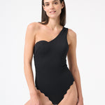 Woman wearing black one piece swimsuit with one shoulder design