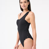 Woman wearing black one piece swimsuit with one shoulder design 
