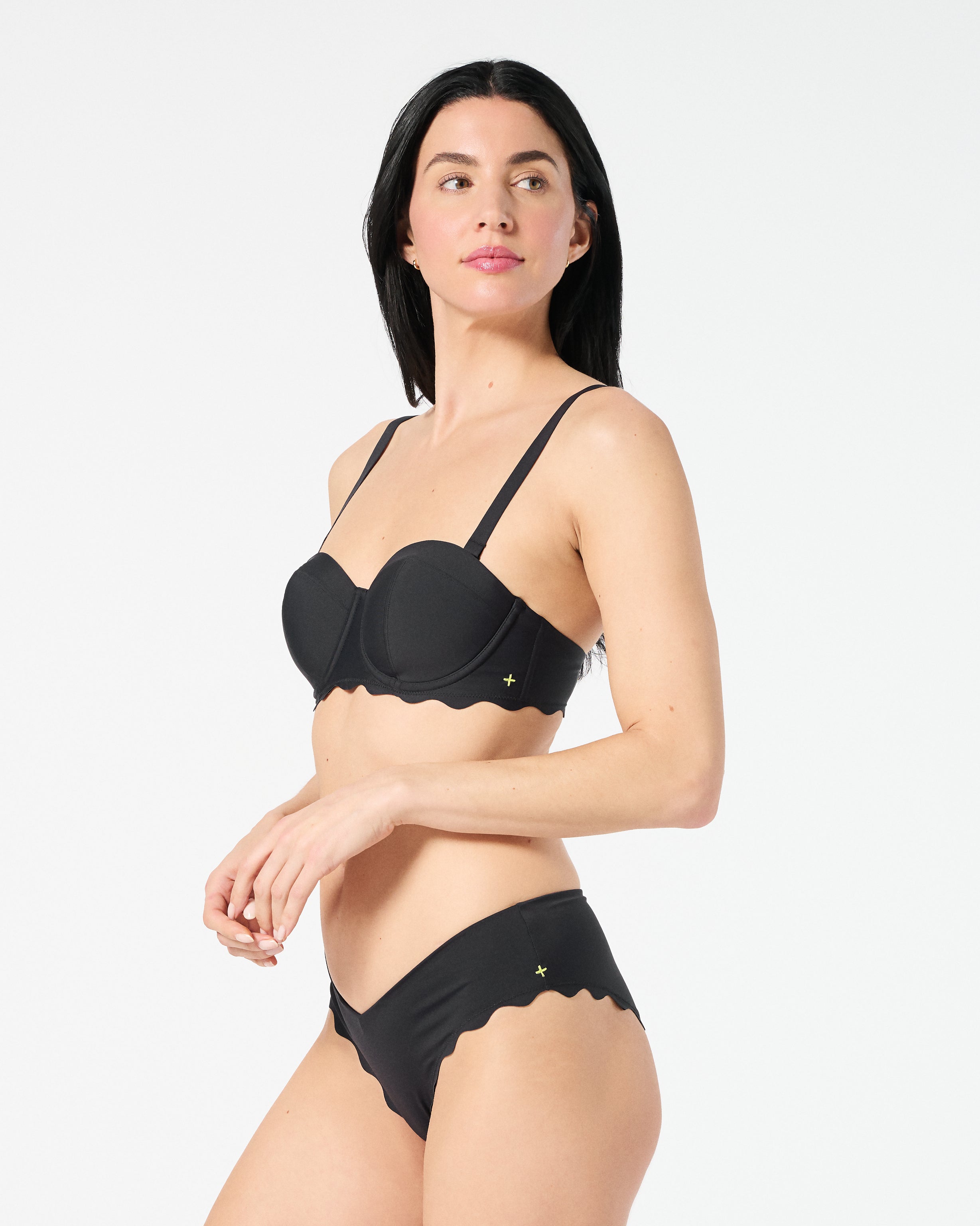 Woman in black balconette bikini top with supportive underwire cups and adjustable convertible straps