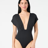 Woman wearing black Gaia OverKini with a deep V-front, sculpting one-piece design, and high-leg fit