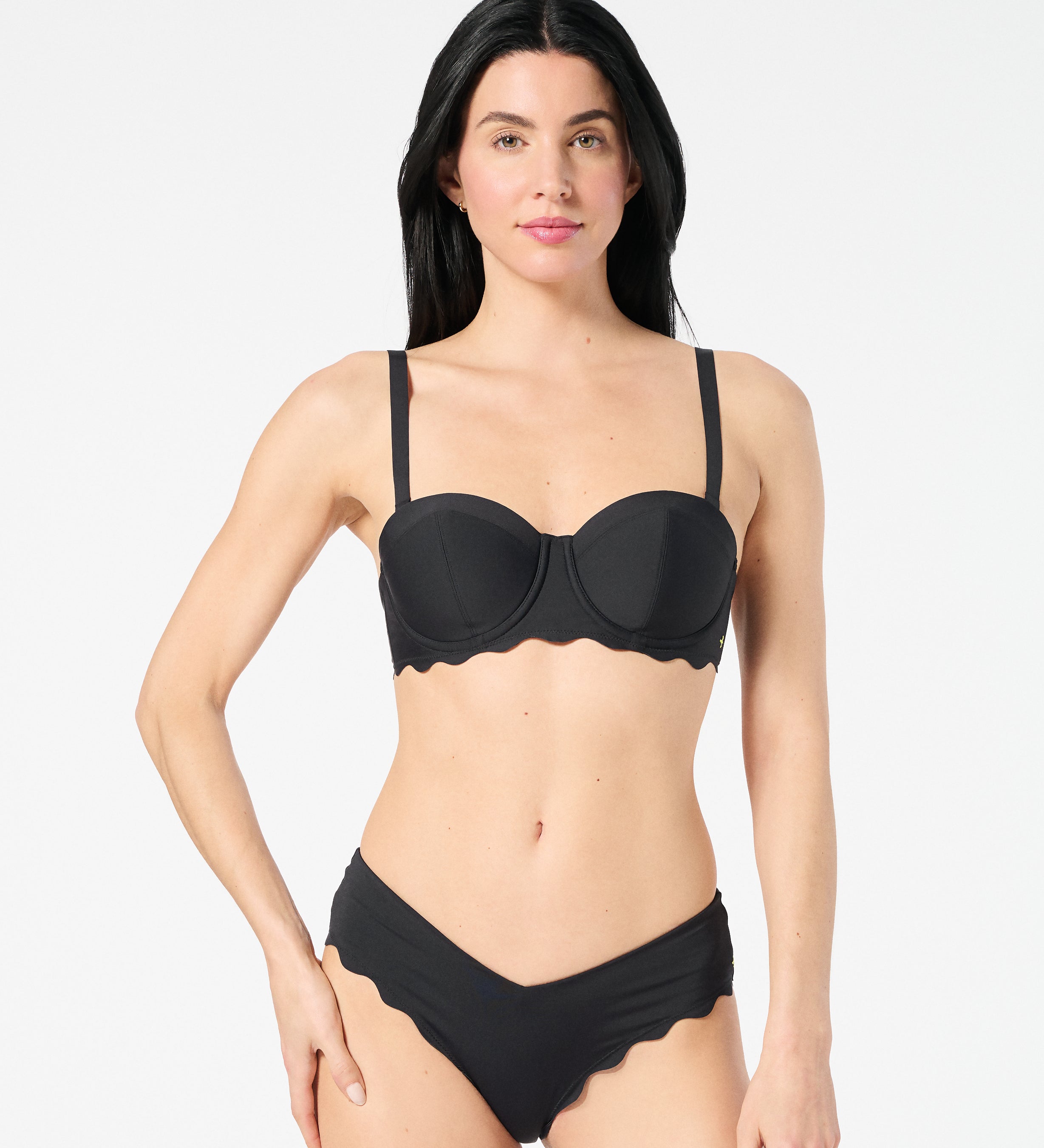 Woman wearing black balconette bikini top with bra-sized lift, smooth fabric, and convertible straps