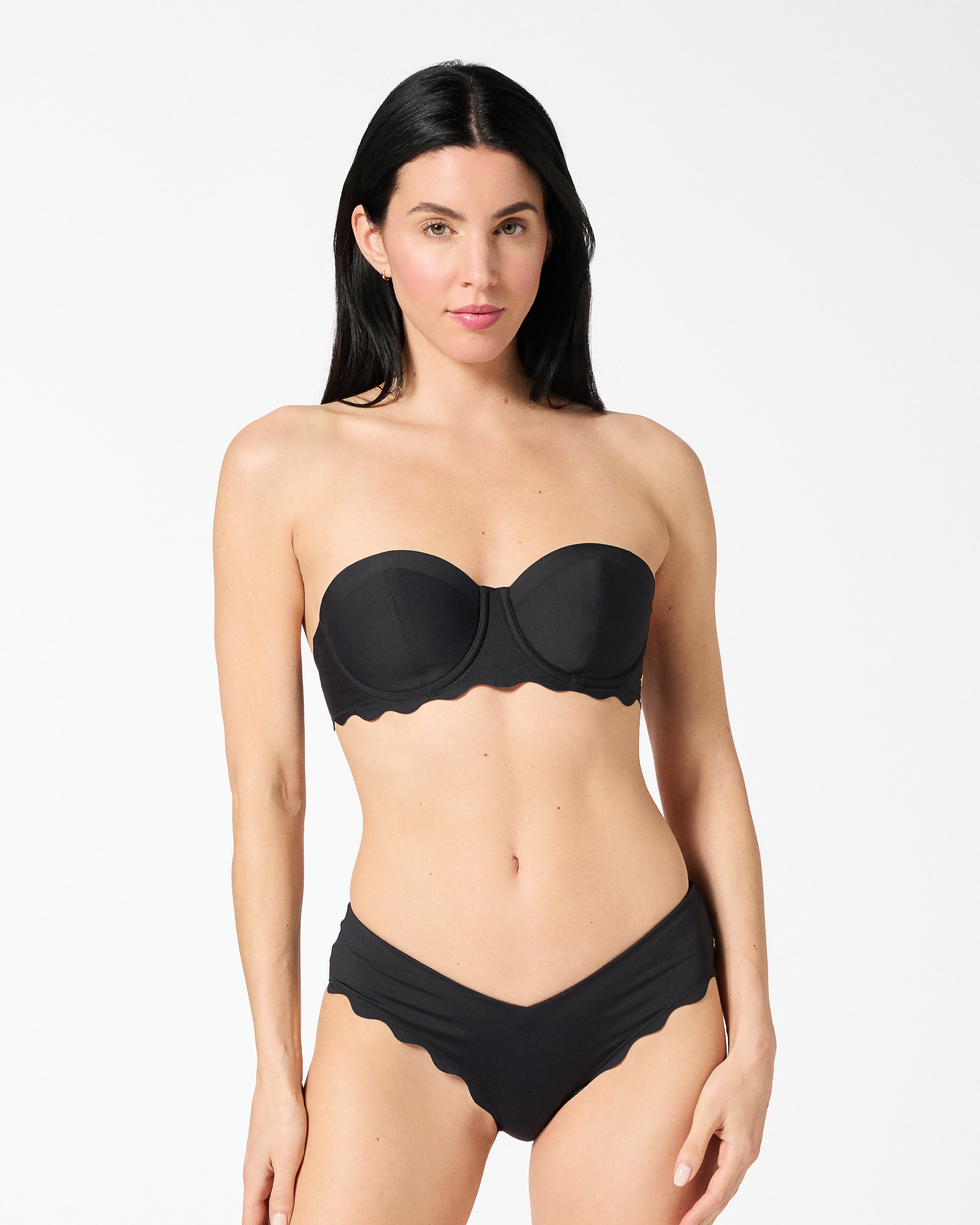 Woman wearing black strapless balconette bikini top with a supportive bra-sized fit and seamless smooth finish