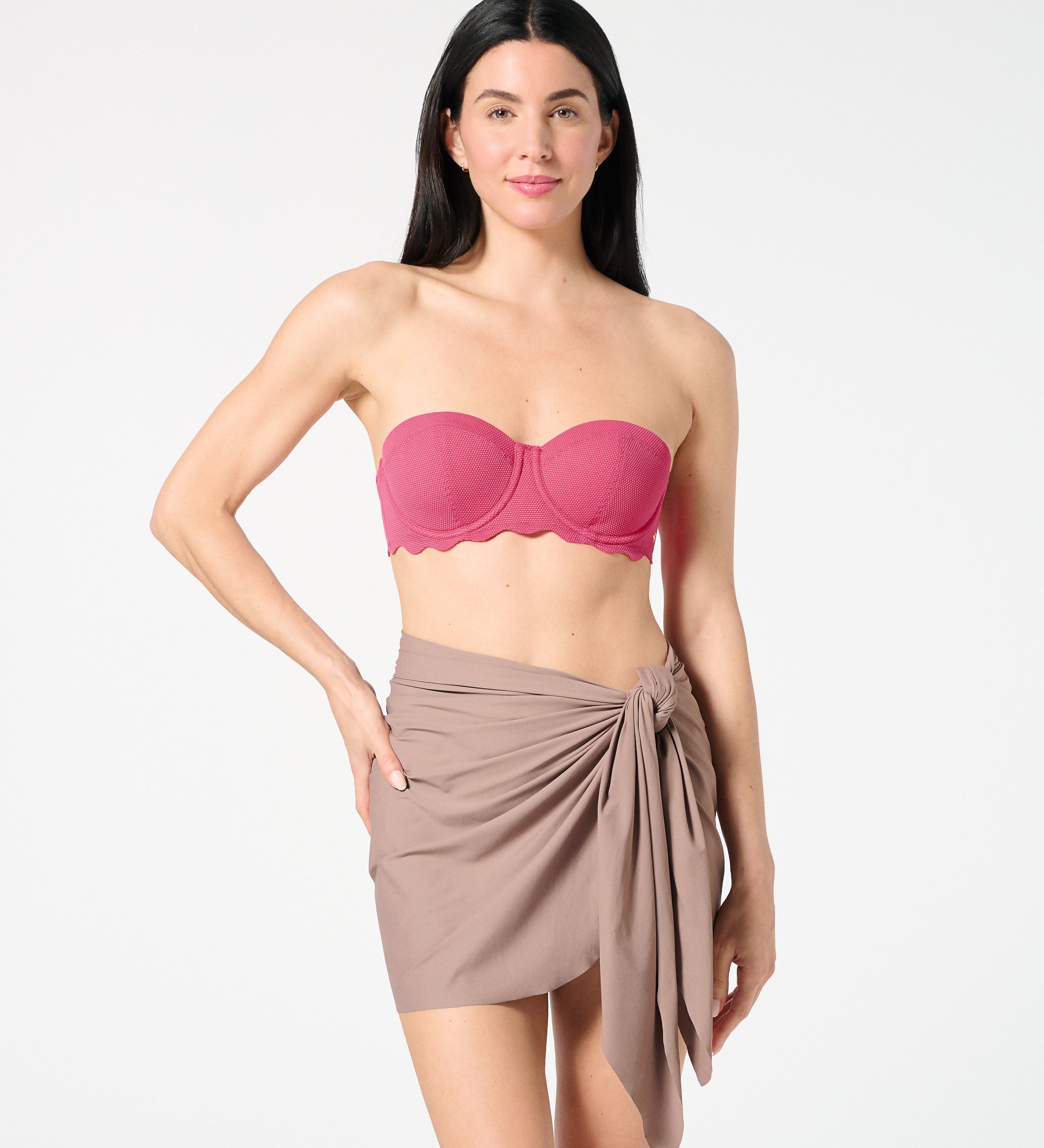 Woman wearing textured Hibiscus balconette bikini top with bra-sized support, paired with a neutral swim sarong for chic beach styling