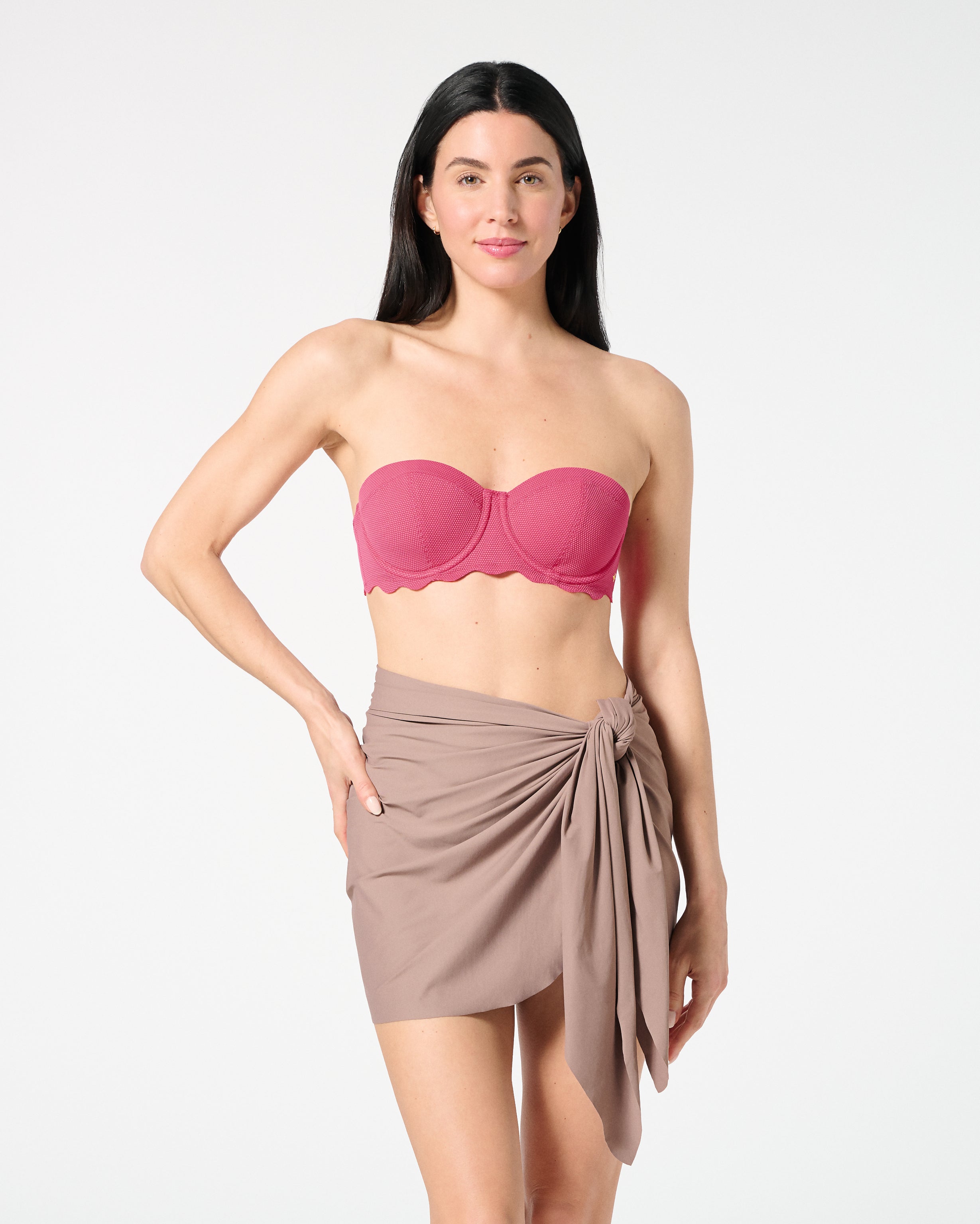 Woman wearing textured Hibiscus balconette bikini top with bra-sized support, paired with a neutral swim sarong for chic beach styling